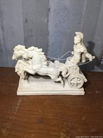 Full side view of the Roman chariot sculpture showing the chariot driver and two horses in motion.