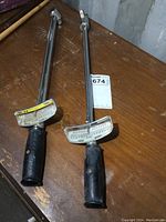 Pair of two Hastings torque wrenches with black handles on wooden surface.