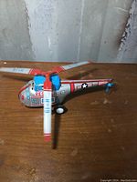 Side view showing colorful rescue markings, wind-up key, and rotors in motion.