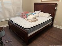 Full assembled bed showing headboard, footboard, mattress, and bedding