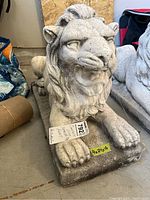 Front view of the concrete lion sculpture showing detailed facial features and mane, with size label 9x24x16.