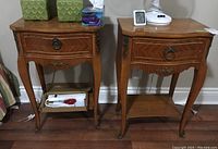 Pair of wooden end tables side by side showing size and scratches with items on top and shelf below