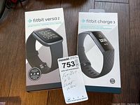 Two Fitbit boxes shown side by side: Fitbit Versa 2 and Fitbit Charge 3