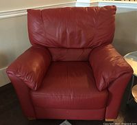 Front view of red leather armchair showing seat, armrests, and back cushions.