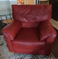 Front view showing cushioned red leather seat, back and armrests on the armchair.