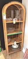 Front view of wicker shelf unit showing overall structure and shelving surfaces.