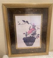 Framed Asian artwork showing two chickadees on a flower branch in a decorative flower pot with visible frame and matting details.