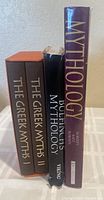 Side view of four books showing spine titles, conditions, and bindings, displaying the two volumes of The Greek Myths, Bulfinch's Mythology, and another Mythology book.