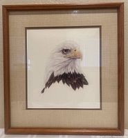 Framed print showing a full view of the bald eagle with neutral beige mat and wooden frame.