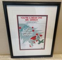 Front view of framed and matted sheet music showing title, printed artwork of the Grinch and black frame.