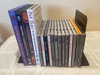 Side view of DVDs and CDs in jewel cases, showing spine titles and cases in good condition.