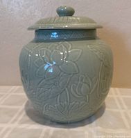 Front view of vintage Andrea by Sadek large lidded jar showing floral embossed design and lid.