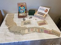 Full lot of about 180 U.S. plate blocks and some additional stamp materials arranged on table, showing stamps in glassine envelopes as well as small boxes containing miscellaneous used stamps and covers.