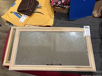 Two rectangular framed mirrors stacked, showing gold-tone textured frames and aged reflective surfaces.