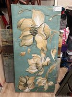 Full view of the canvas print wall art with floral design in beige and cream on a muted green background.