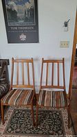 Front view of two teak dining chairs side by side