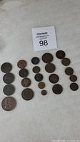 Full layout of 21 assorted vintage coins showing varied sizes and metal tones.