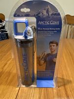 Photo showing the front of the Arctic Cove misting bottle in package with blue handle and nozzle, 16 oz capacity noted on packaging.