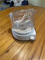 Black & Decker Handy Steamer electric rice cooker showing white base, clear plastic steaming basket and power cord inside, placed on wood surface.