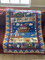 Full view of the quilt with Noah's Ark central design and colorful patchwork border.