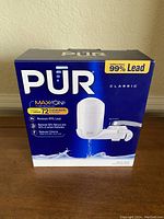 Image of the PUR Classic Maxion faucet water filter in the original box showing branding and contamination removal claims.