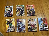 Seven Yu Gi Oh 5D's manga volumes arranged on hardwood surface.