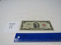 Front view of 1953 A Red Seal two dollar bill with ruler showing size.