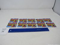 Wide shot showing all 10 unopened 1989 Topps Baseball card packages laid out with a ruler for scale.