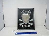 Front view of black picture frame with skull and crossbones design and 'Danger Beware' text.
