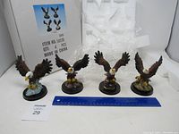 Four eagle figurines displayed with ruler for scale, showing their size and detail.