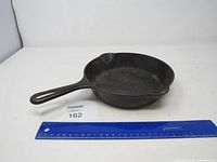 Full view of the Griswold #5 cast iron skillet with a ruler for scale.