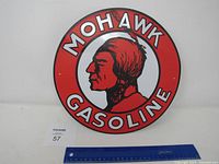 Photo of front face of red Mohawk Gasoline metal round sign showing the logo and profile image clearly.