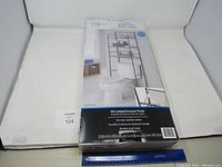 Boxed Mainstays 3-Shelf Bathroom Space Saver unit with label showing oil-rubbed bronze finish and size details.