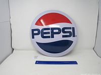 Front view of Pepsi metal round sign showing logo and condition