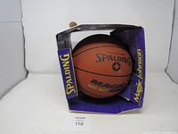 Front view of Spalding Magic Johnson NBA MVP basketball in original box, showing packaging and ball branding.