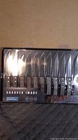 Front view of the 12 steak knives in original packaging, showing wooden handles and stainless steel blades.