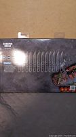 Box packaging showing the outline illustrations of the 12 steak knives on a dark background.