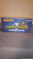 Front view of unopened Drinkopoly game box showing title and design