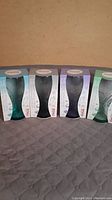 Four Coca-Cola 2014 limited edition glasses in original boxes, different color tints, unopened and new condition.