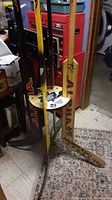 Coat rack made from painted and signed hockey goalie sticks with visible wear, damage and stickers