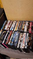 Photo showing most of the DVD lot placed on a flat surface, displaying full rows of cases with titles partially readable.