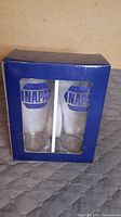 Front view of blue box packaging showing two clear drinking glasses with large blue NAPA logo.