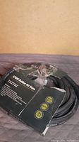 Coiled black EPDM rubber air hose with damaged packaging showing specifications including 25 ft length and 3/8 inch diameter