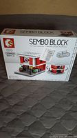 Front of box showcasing Sembo Block brand and image of the completed building model with box damage visible.
