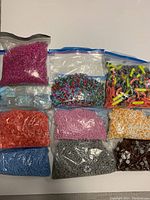 Top view of 10 Ziploc bags containing assorted building bricks sorted by color and type, showing a variety of colors including pink, red, blue, gray, orange, brown, and multi-colored mixed pieces.