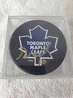 Front side of the hockey puck showing the Toronto Maple Leafs logo and Gary Valk's gold autograph.