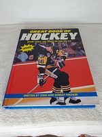 Front cover of the Great Book of Hockey showing a hockey player in black and yellow uniform, published by Stan and Shirley Fischler.