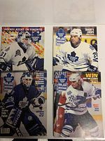 Four Toronto Maple Leafs hockey game programs placed on a white surface. Covers show Curtis Joseph, Felix Potvin, and two Tie Domi images. Visible wear and tear on covers.