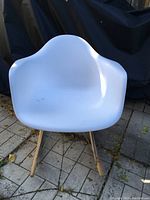 Front view of white plastic bucket rocking chair showing seat and legs