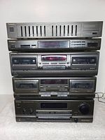 Front view of the five Technics stereo components stacked vertically: equalizer, tuner, two cassette decks, and stereo receiver at bottom.